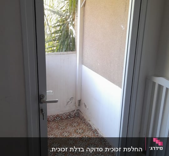 דלת זכוכית עם מסגרת לבנה ומנעול כסוף